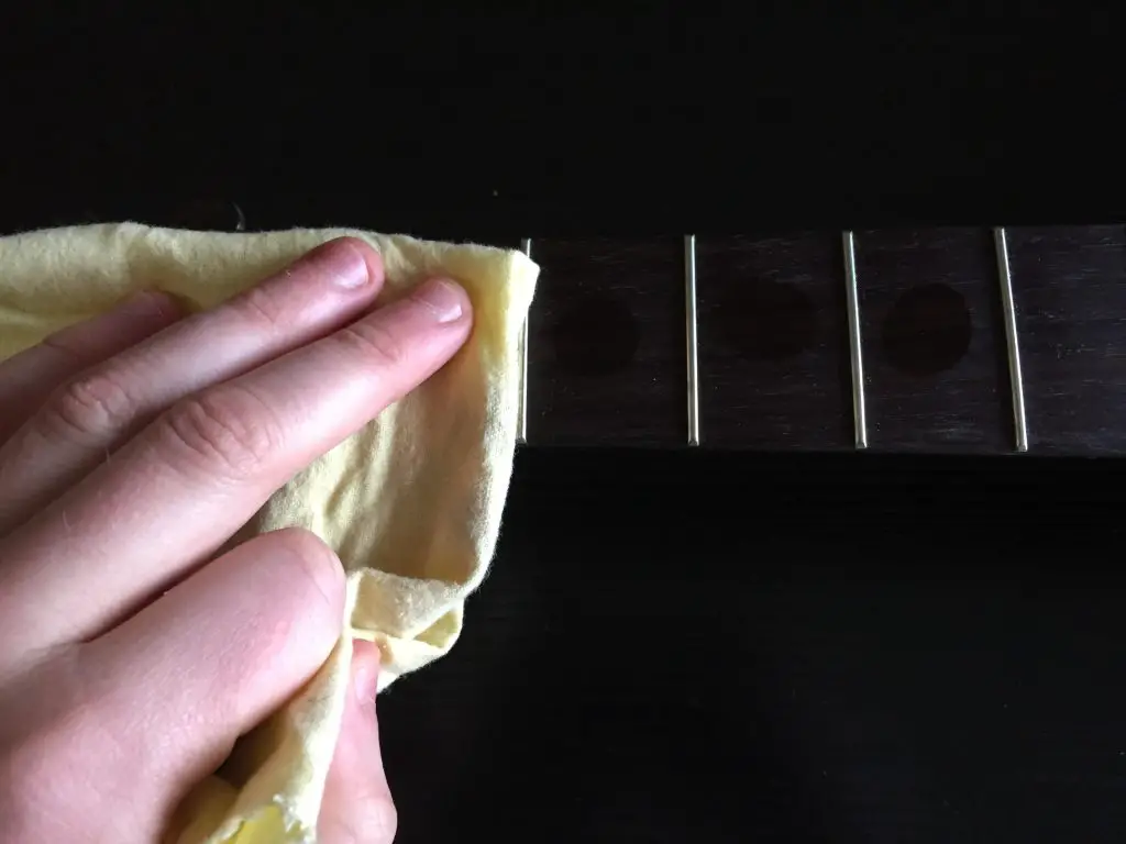 wiping down guitar fretboard